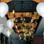 Modern interior featuring hanging Edison bulbs and white balloons for elegant decor.